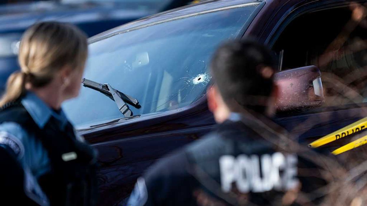 A car with a bullet hole in the windshield.