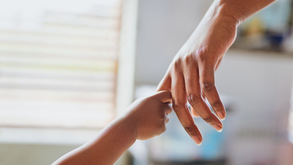 A child's hand holding an adult's hand.