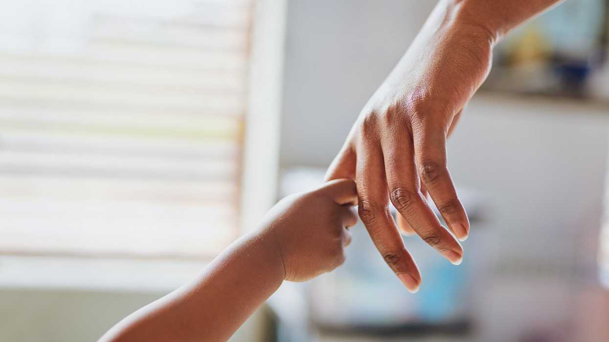 A child's hand holding an adult's hand.