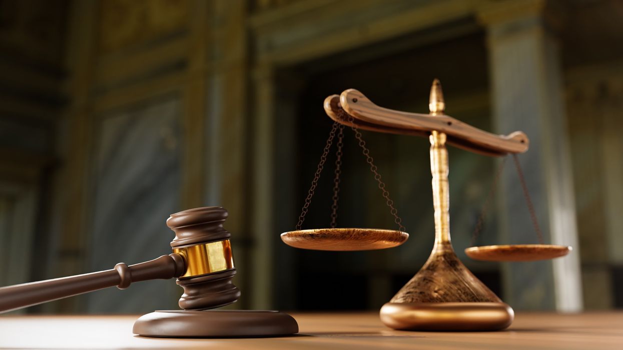 A gavel and a scale of justice on a table.