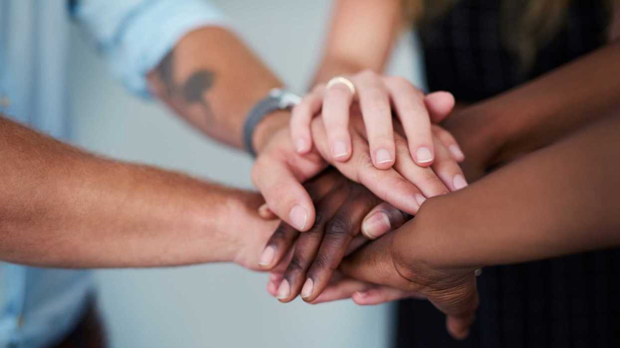 A group of people joining their hands in solidarity.