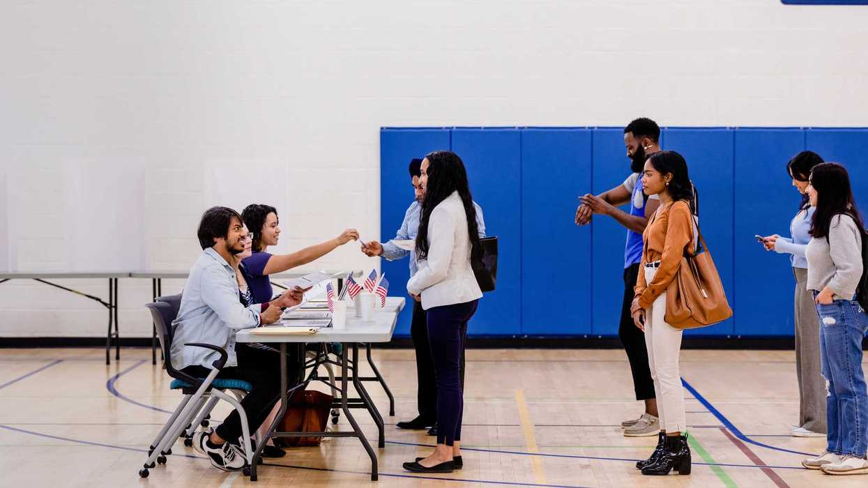 A group of people wait in line to get their ballots to vote in the election.