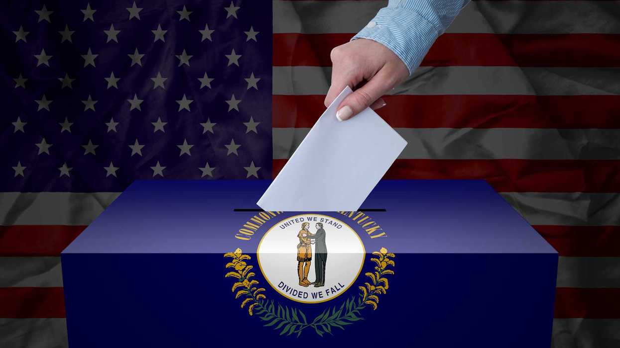 A hand casting a vote in a ballot box for an election