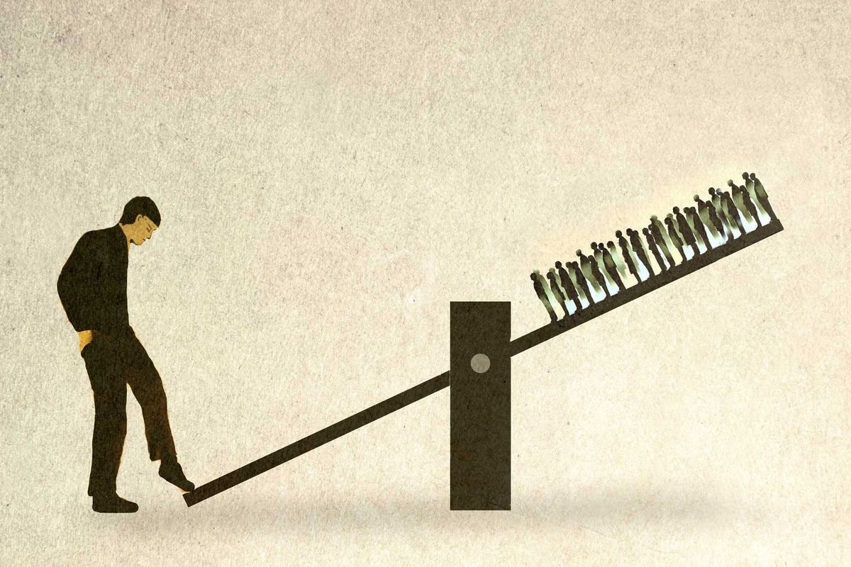 A man standing and tilting a seesaw, with a crowd of people standing on the other side.
