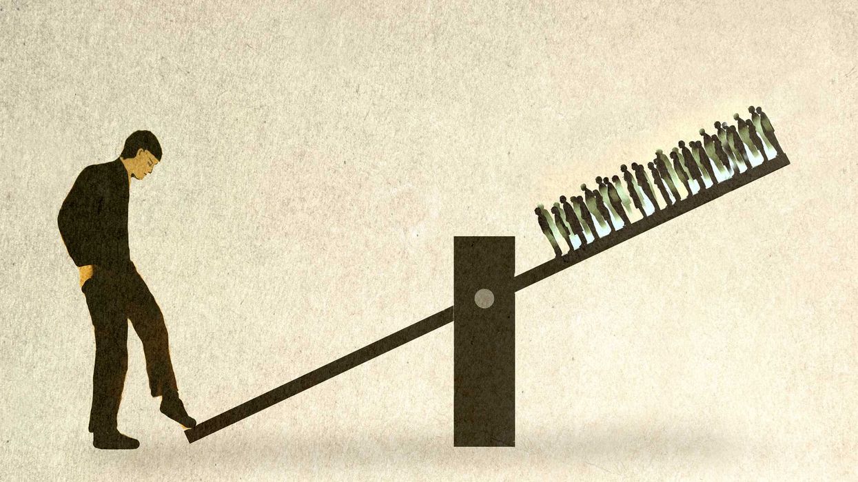 A man standing and tilting a seesaw, with a crowd of people standing on the other side.