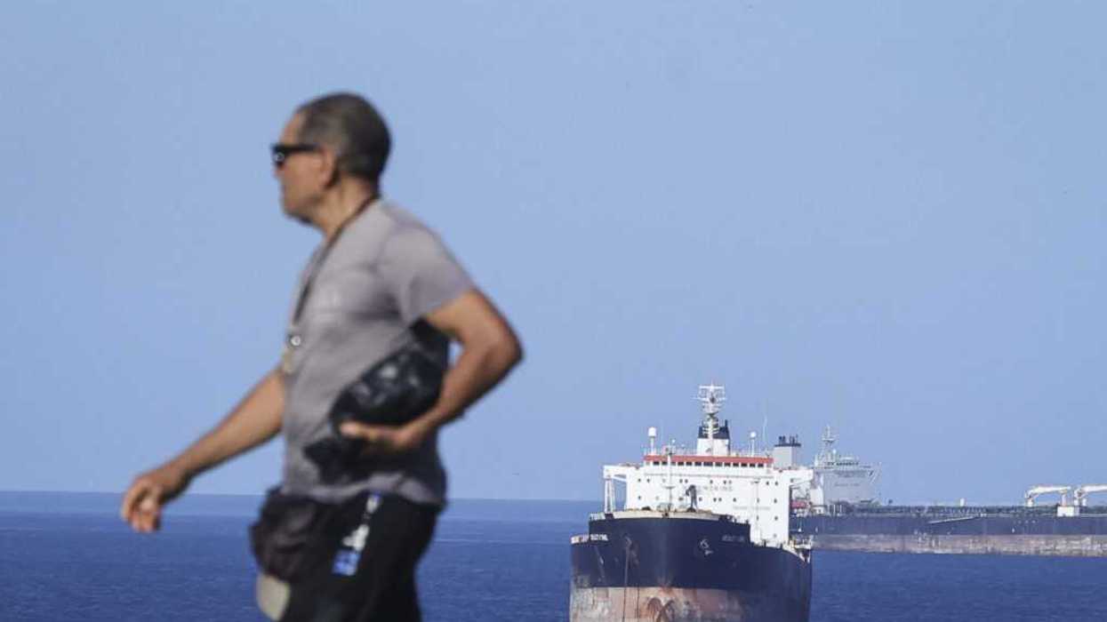 A man walks with a ship behind him