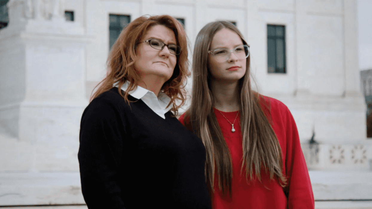 A mother and daughter standing together.