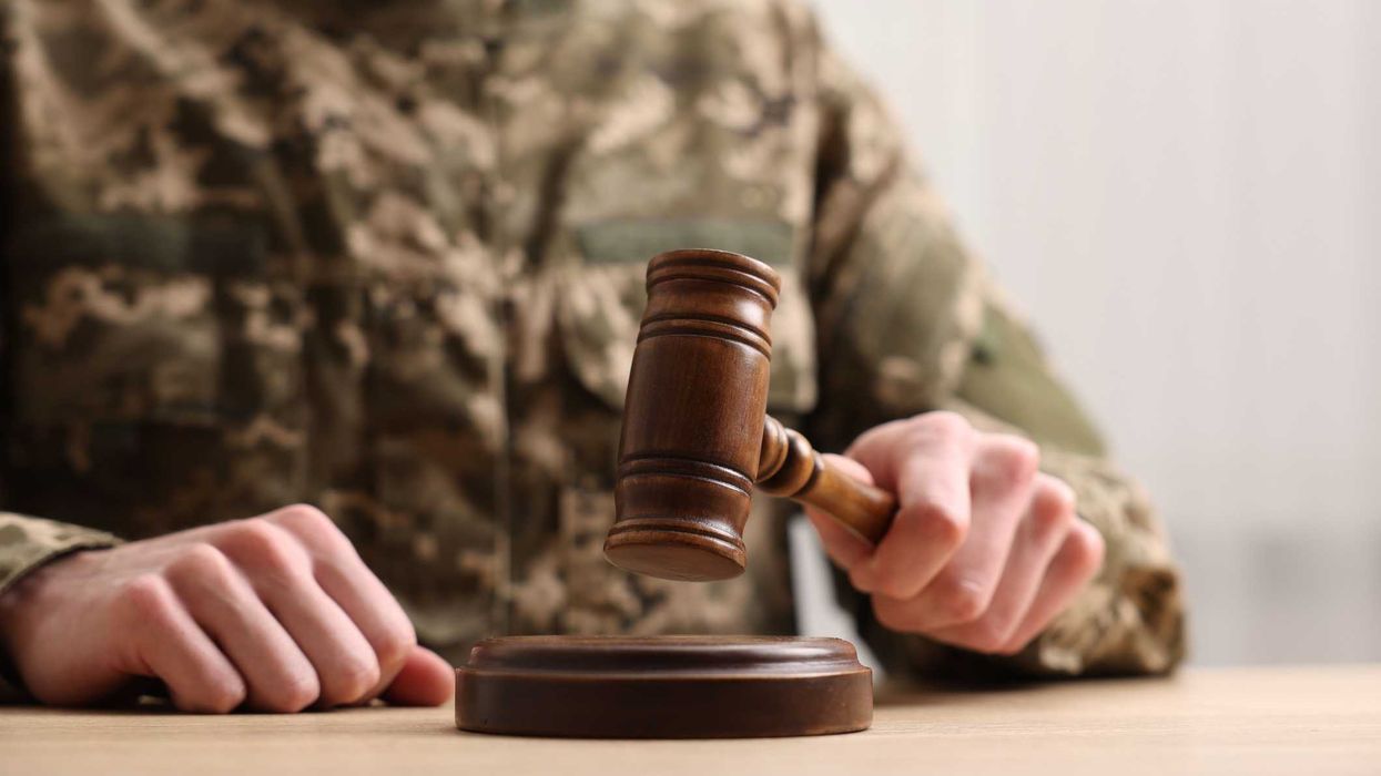 A person in a military uniform holding a gavel.