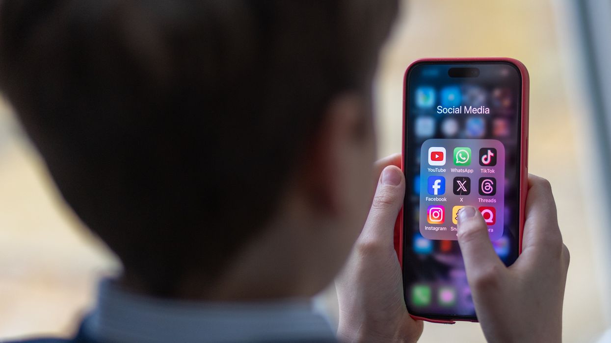 A person looking at social media app icons on a phone