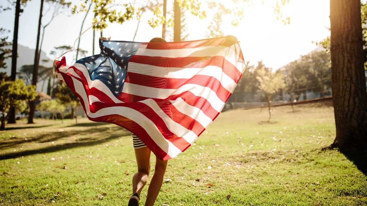 A person running, holding the U.S. flag behind them.
