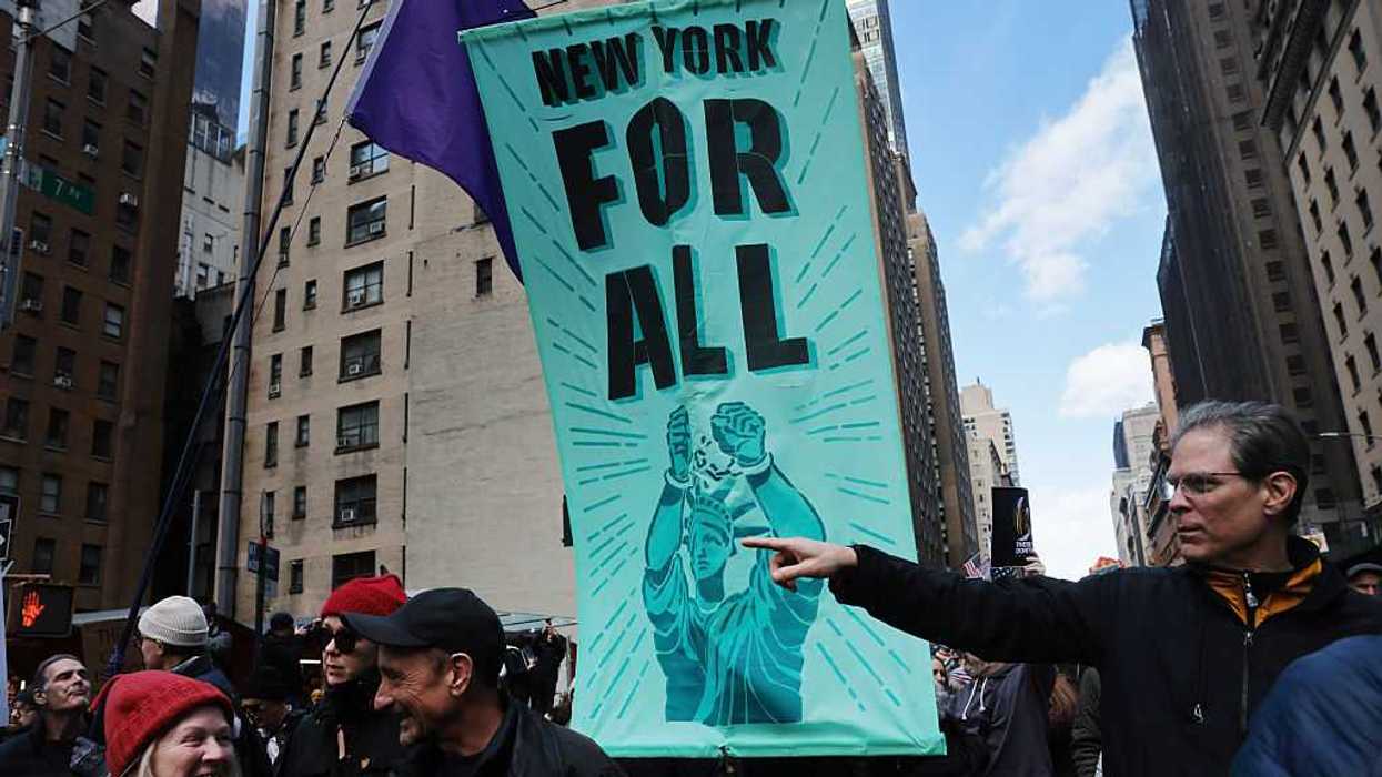 A sign reading, "New York For All," held by people in a protest.