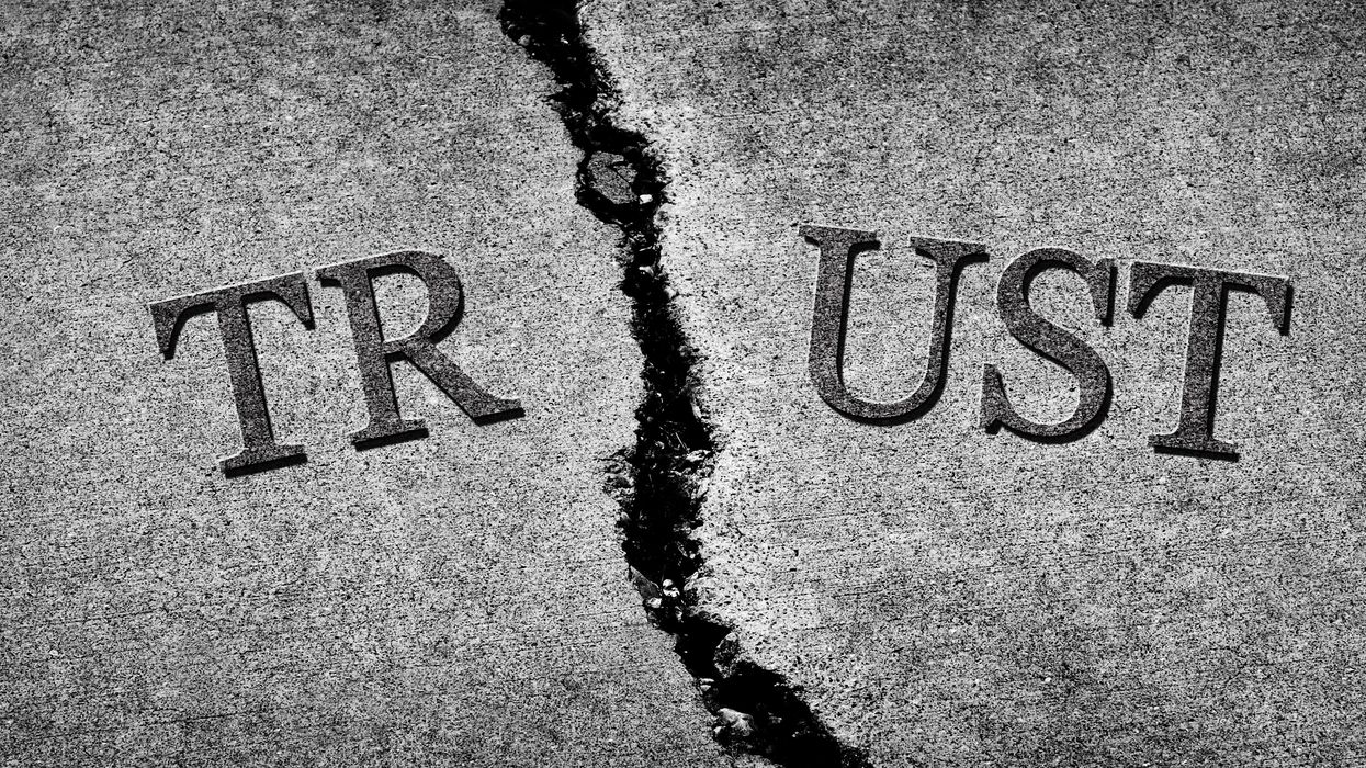 A sign reading "Trust" cracked in half