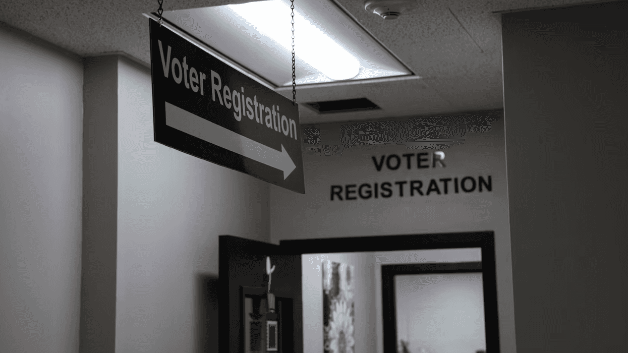 A sign that reads, "Voter Registration," hanging from the cieling, pointing to an office with the words, "Voter registration," above its doorway.