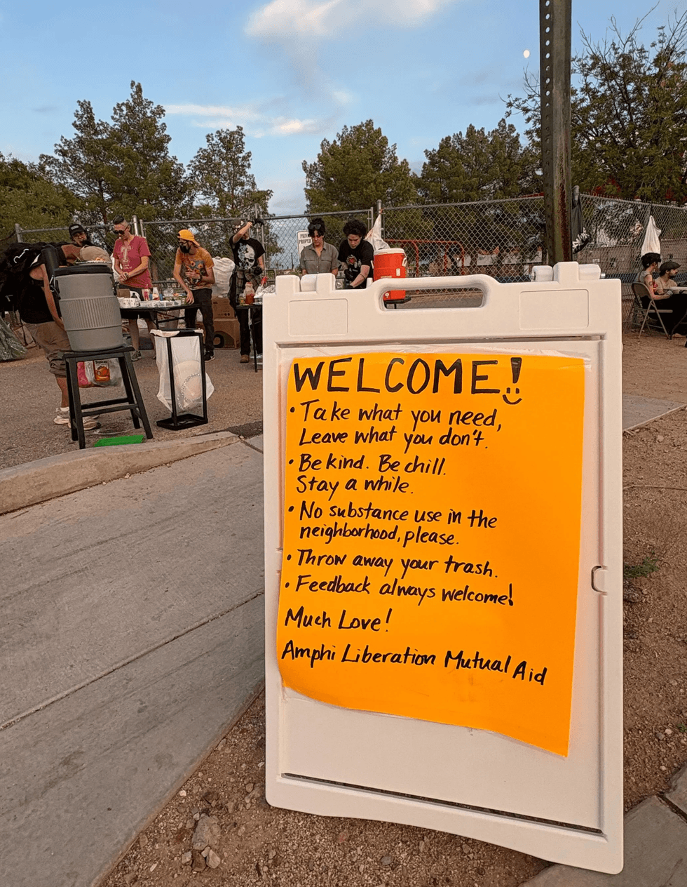 A sign welcomes visitors to the weekly mutual aid distribution in Amphi Park in Tucson