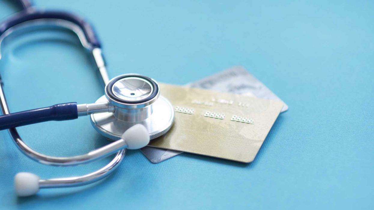 A stethoscope lying on top of credit cards.