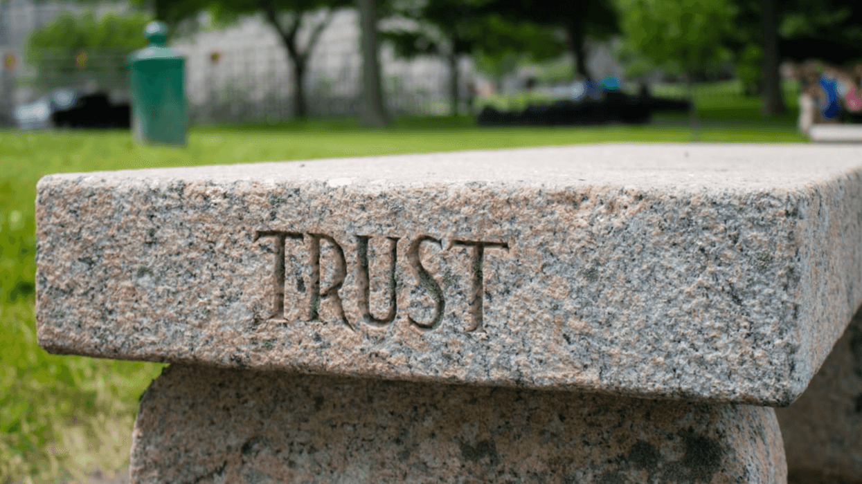 A stone bench with the word "Trust" etched in its side.
