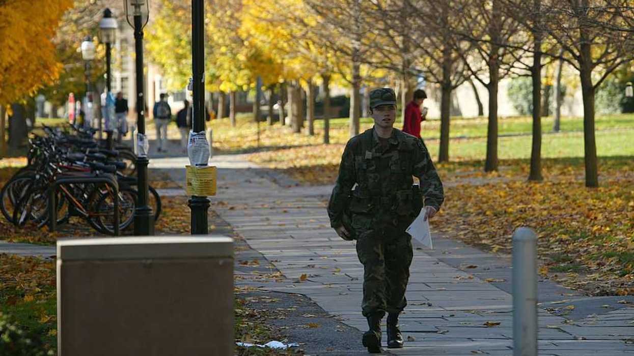 A student in uniform walking through a campus.