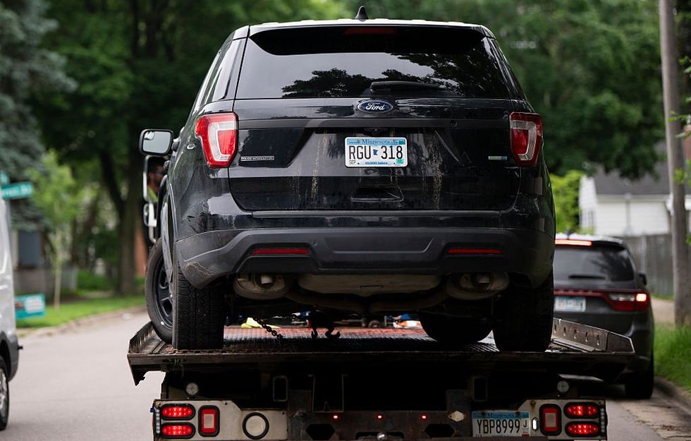 A vehicle belonging to Vance Boelter is towed from the alley