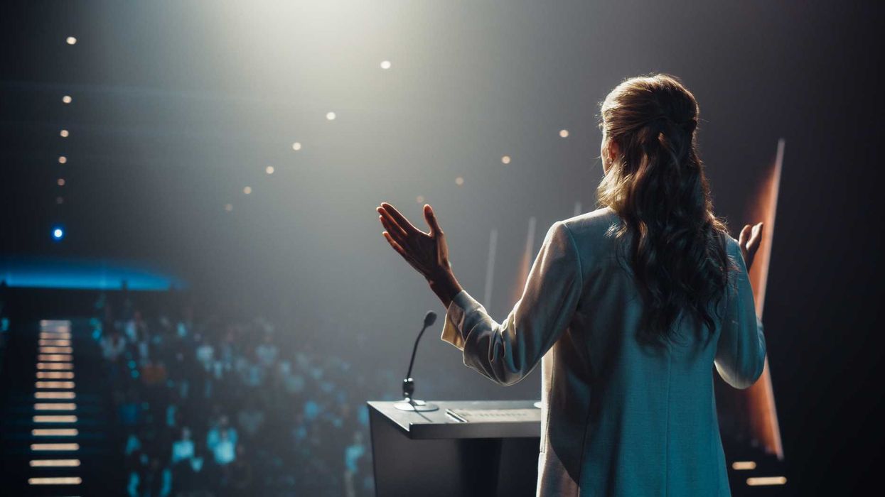 A woman speaking in front of an audience.