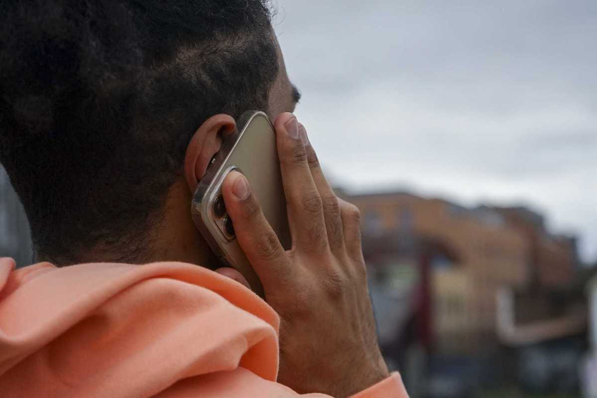 A young man holding a smartphone to his ear.