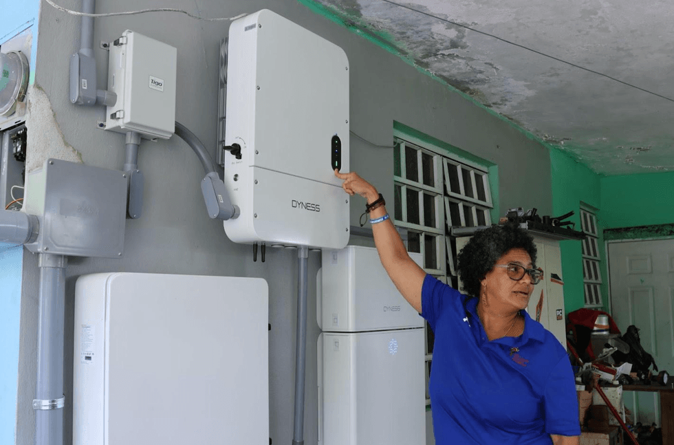 Ada Miranda explains a solar system to a family who recently had rooftop solar panels installed on their home