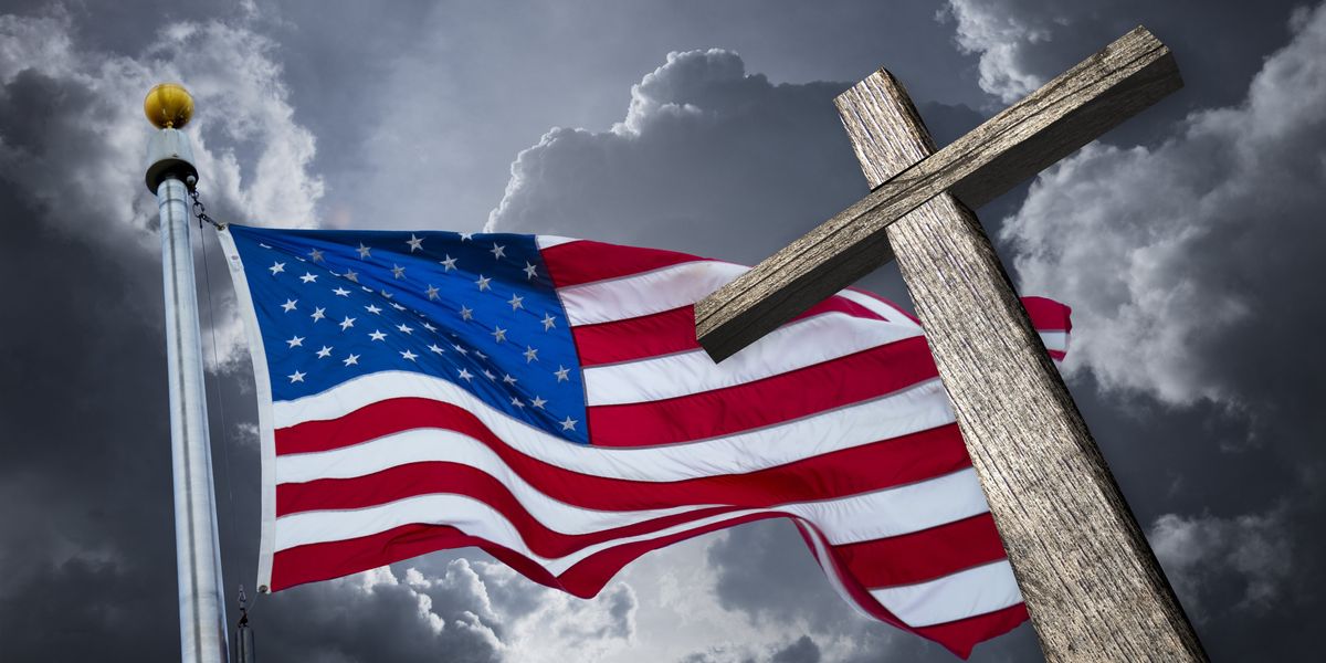 American flag and cross against a dark sky