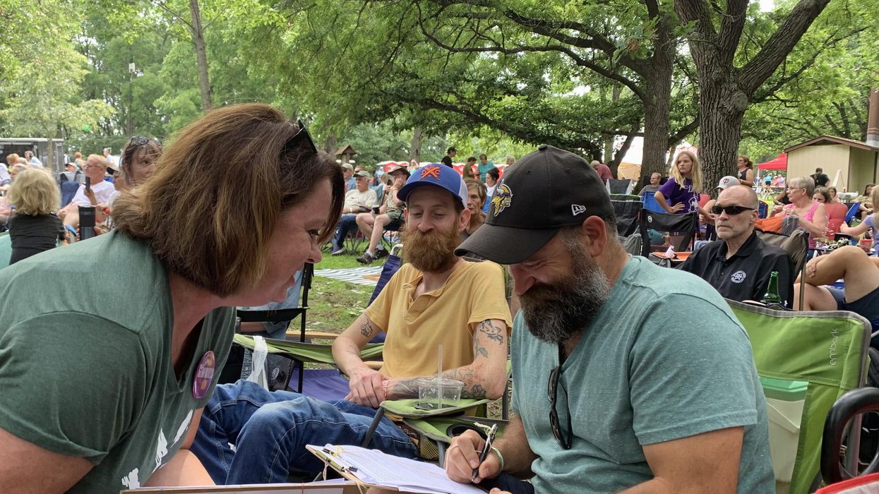 Amy Scott-Stoltz collects petition signatures at the Sioux River Folk Festival on Aug. 7.