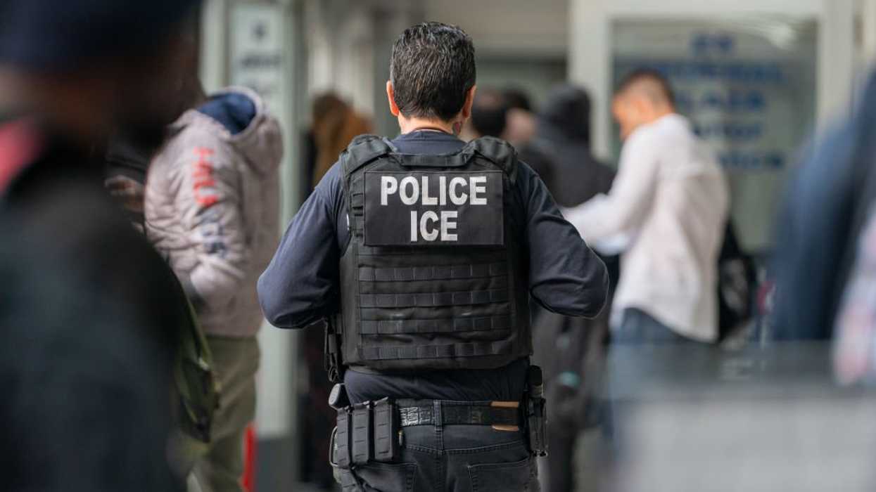 An ICE agent monitors hundreds of asylum seekers being processed upon entering the Jacob K. Javits Federal Building on June 6, 2023 in New York City. New York City has provided sanctuary to over 46,000 asylum seekers since 2013, when the city passed a law prohibiting city agencies from cooperating with federal immigration enforcement agencies unless there is a warrant for the person's arrest.(Photo by David Dee Delgado/Getty Images)