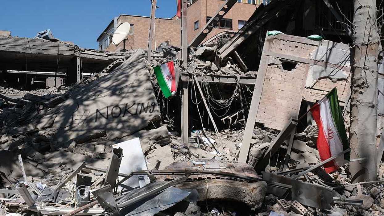 An Iranian flag and the message "No King" graffitied on the ruins of the data center building of Sharif University of Technology after a U.S.-Israeli missile strike on April 7, 2026 in Tehran, Iran.