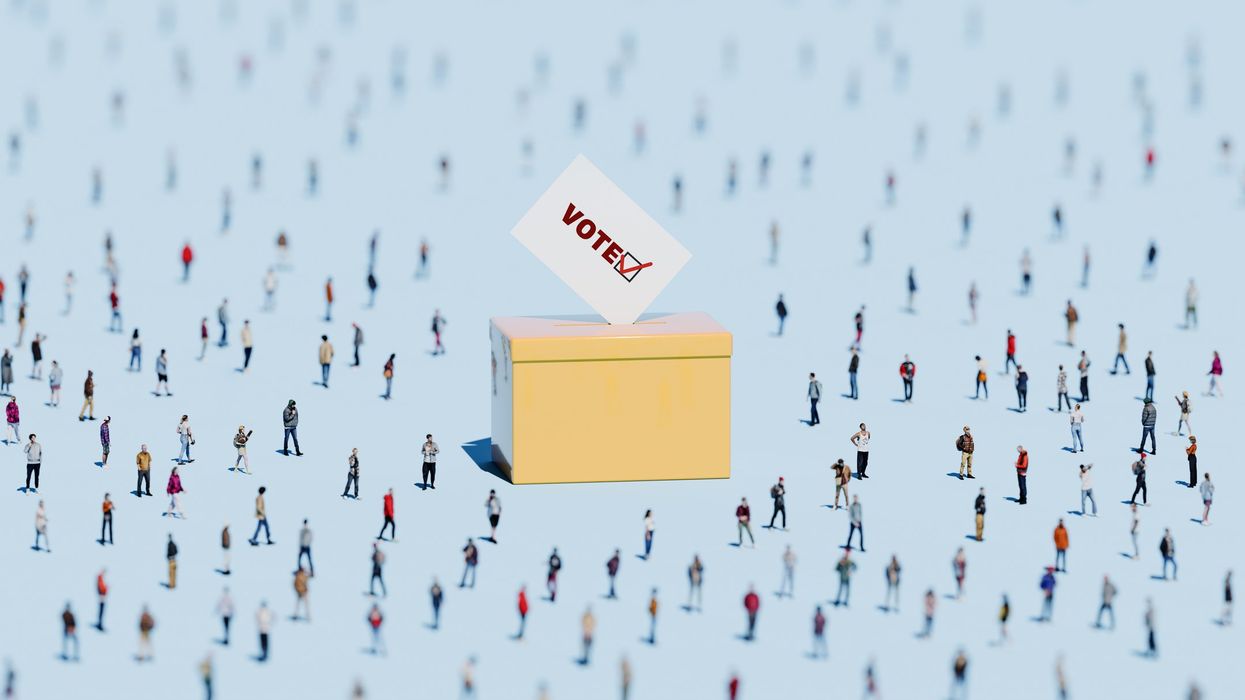 An oversized ballot box surrounded by people.