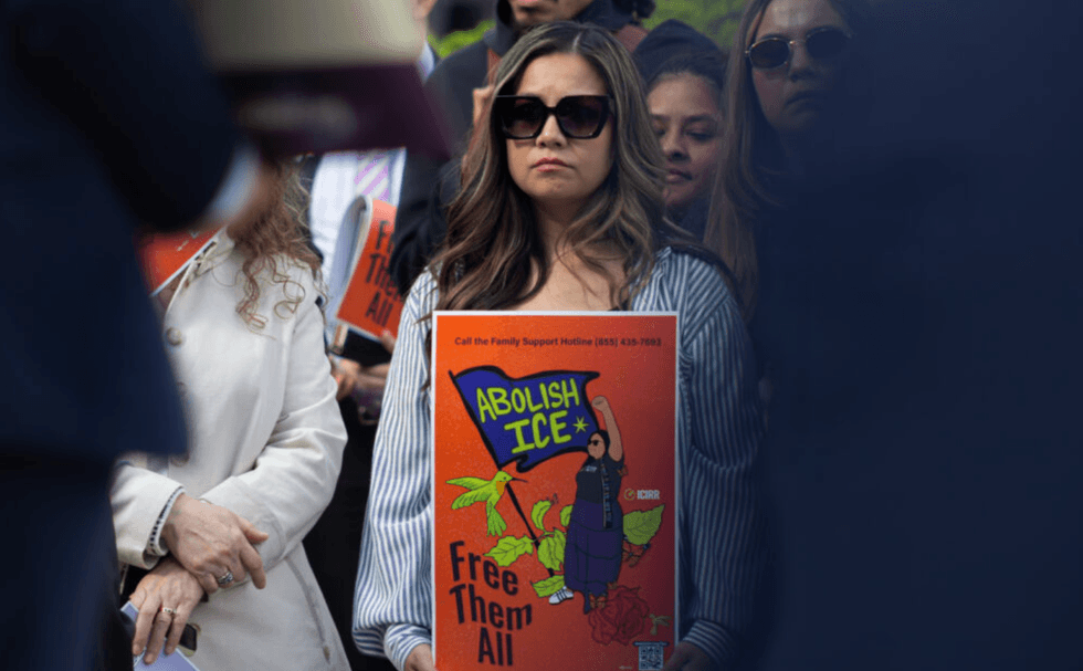 Attendee at Latino Unity Day holds an \u201cAbolish ICE\u201d poster