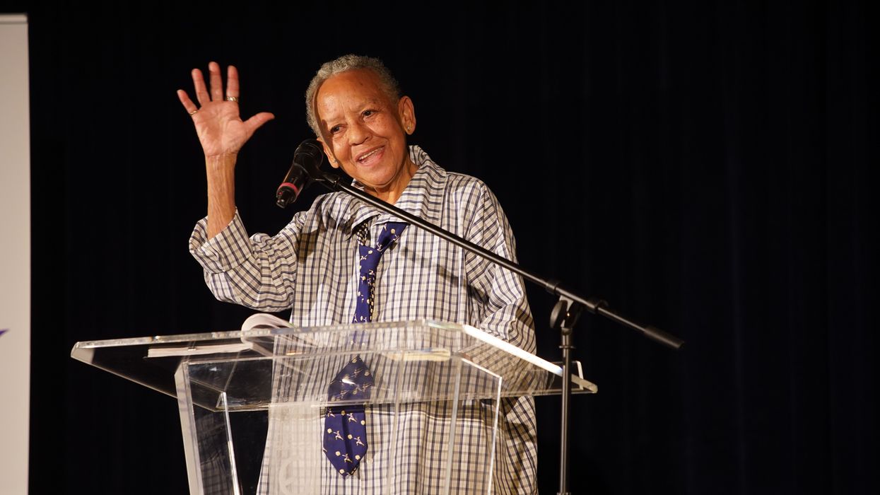 Black woman waving from a podium