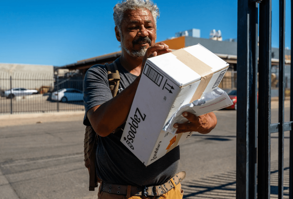 Carl Steiner opens a box of shoes for a new job at a warehouse
