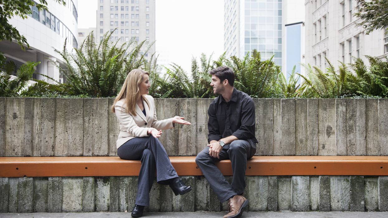 Caucasian business people talking on bench outdoors