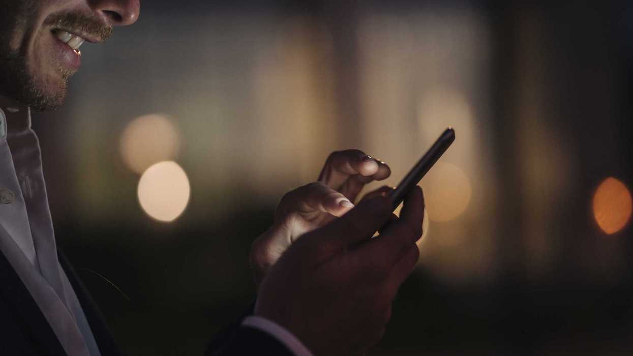 Close up of a person on their phone at night.