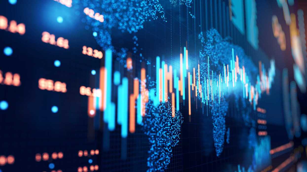 Close up of stock market chart on a glowing particle world map and trading board.