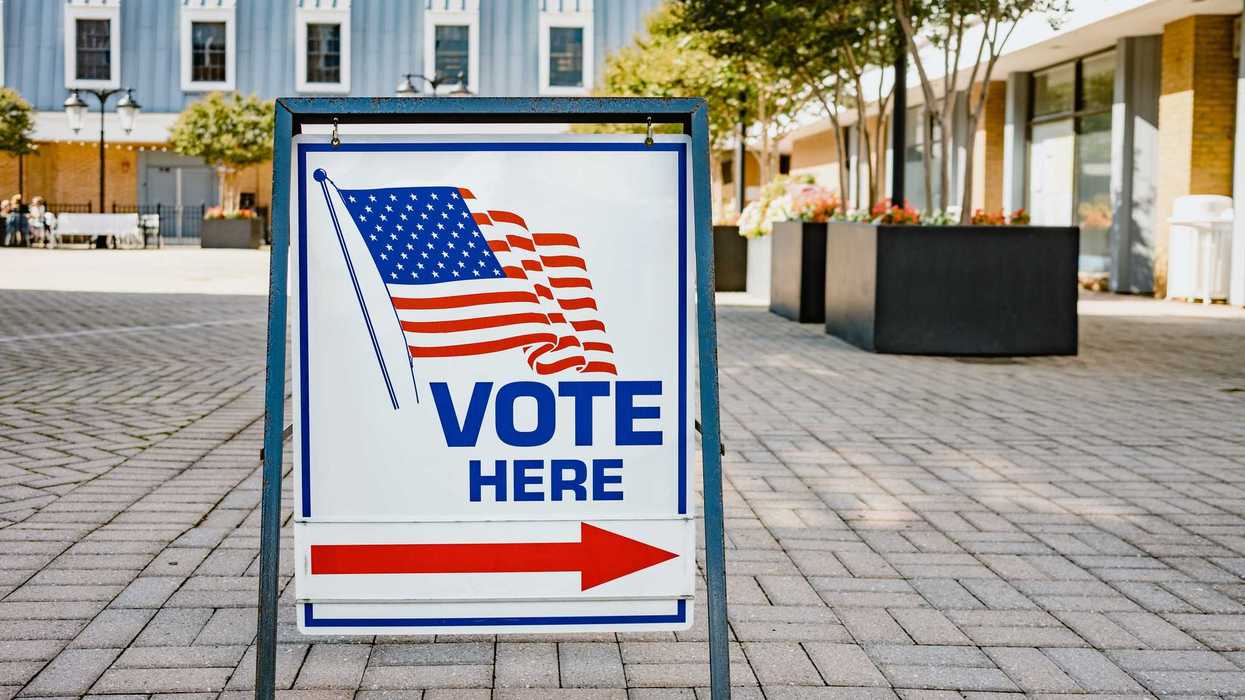 Close-up of "Vote Here" directional sign at polling place