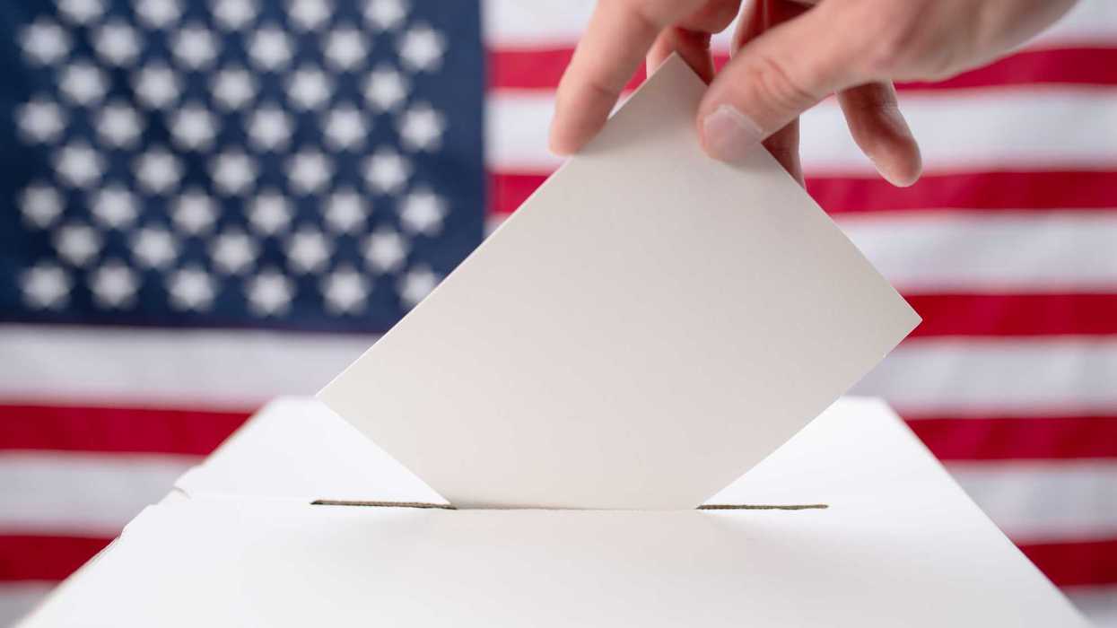 Close up of white ballot box with American flag in the background