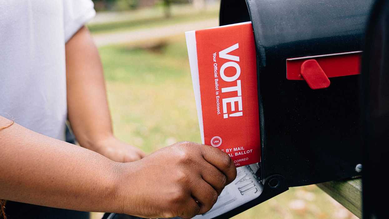 Close-up shot of a Black woman's hands receiving a mail-in ballot to vote in a USA Presidential, Senatorial, Congressional, or local election
