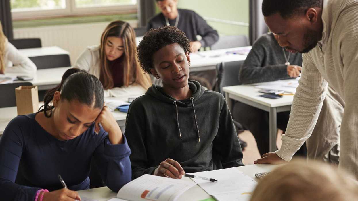 Creative Images Creative Images & Video Images Creative Editorial Video Creative Editorial Search by image or video Teenage boy getting help from male professor in solving math problem at school