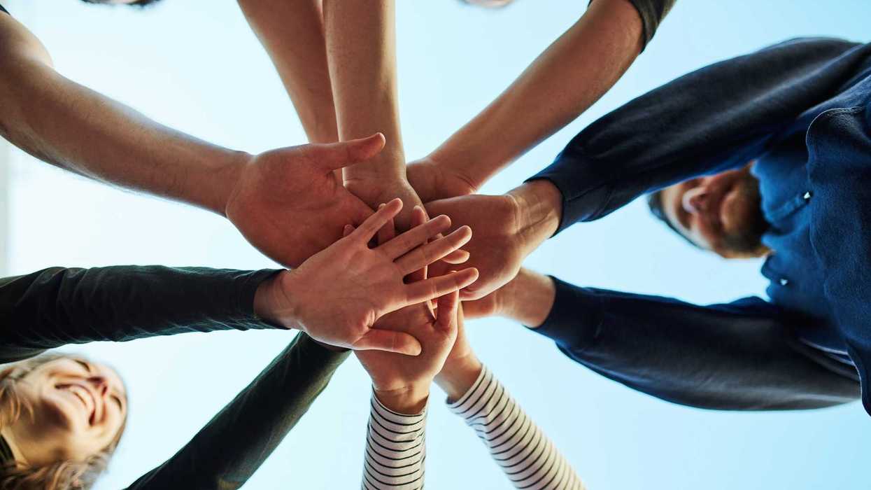 Cropped shot of a group of people joining their hands in solidarity