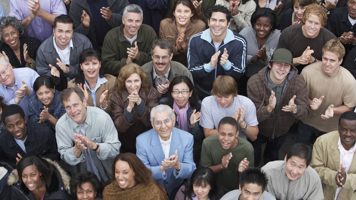 Crowd of people looking up and clapping