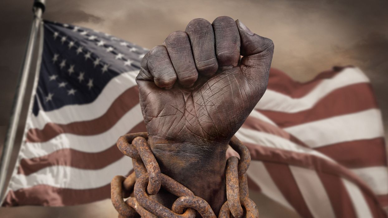 Dark hand in chains, in front of an American flag