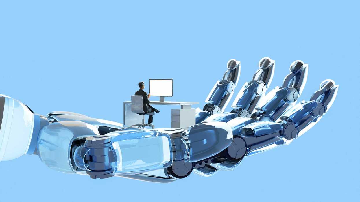 Digital illustration of robot's hand holding and supporting man who is working on his desk using computer, represent themes of artificial intelligence (AI), the future of work, and the intersection of humanity and technology.
