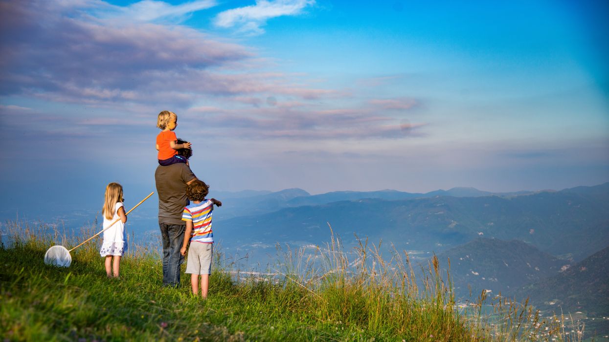 Father looking out over a valley with three children