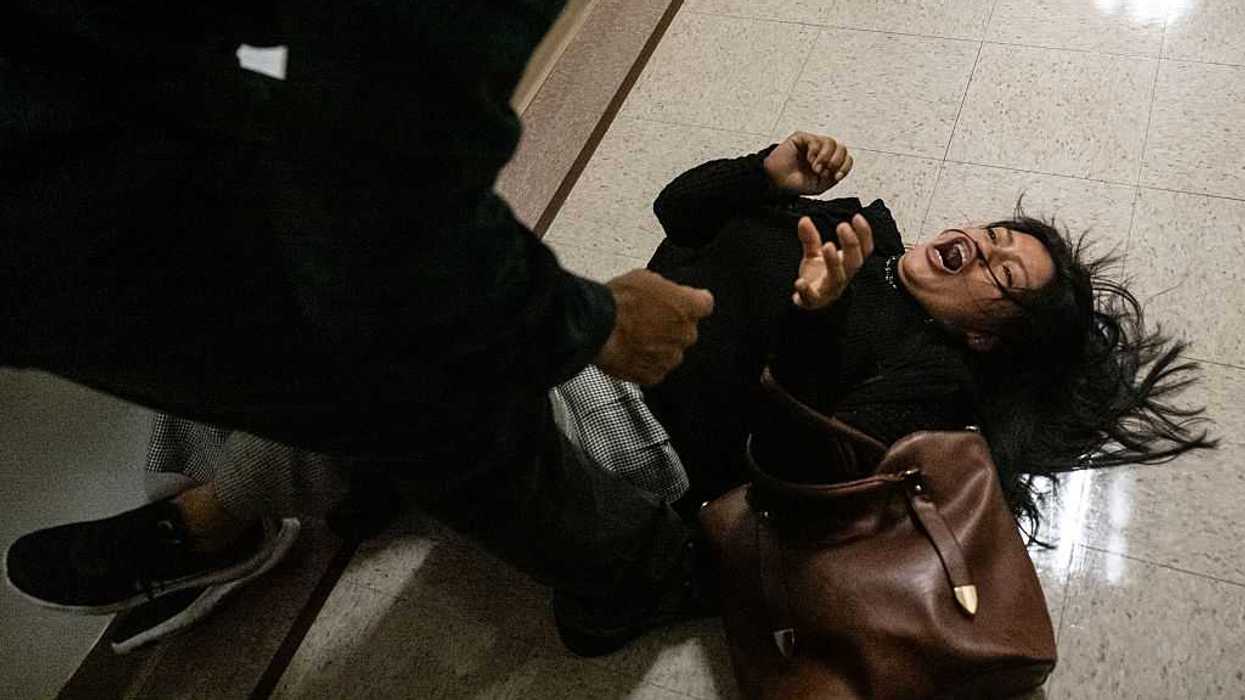federal agent pushes the wife of a detained man