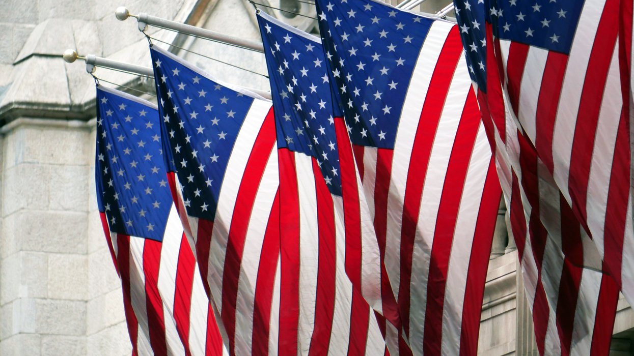 Flags of the United States hanging in front of the facade of a building