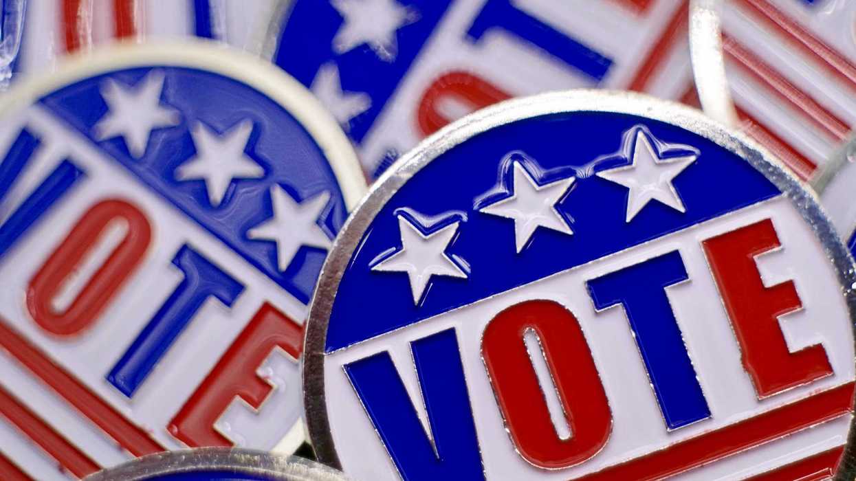 Full frame shot of pins that say “vote” with red, white, and blue American flag theme.