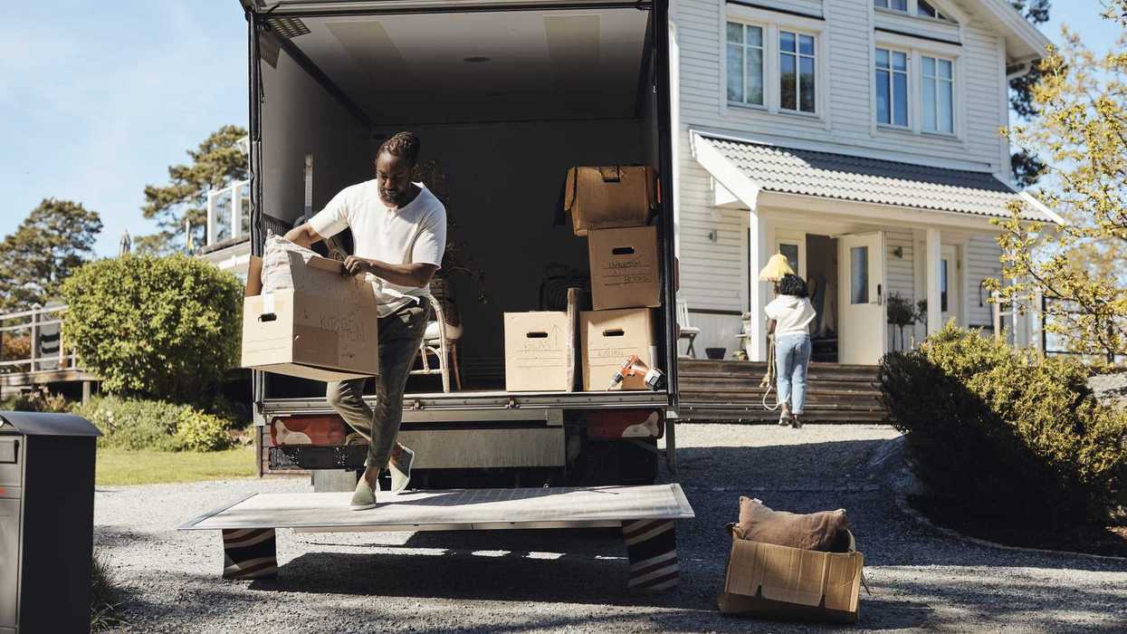 Full length of man unloading cardboard box from van