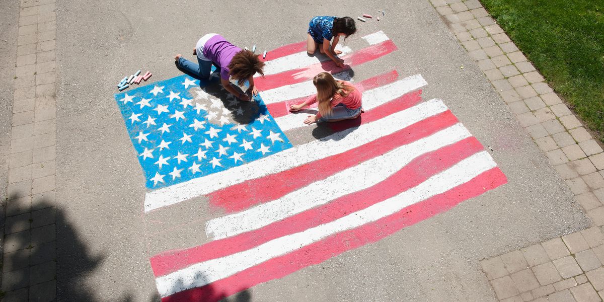 Girls coloring an American flag with chalk